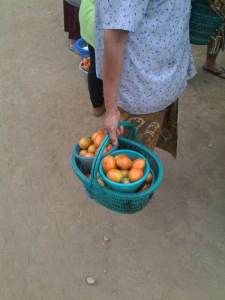 A woman is carrying her oranges.